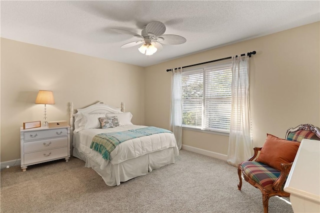 carpeted bedroom with ceiling fan and a textured ceiling