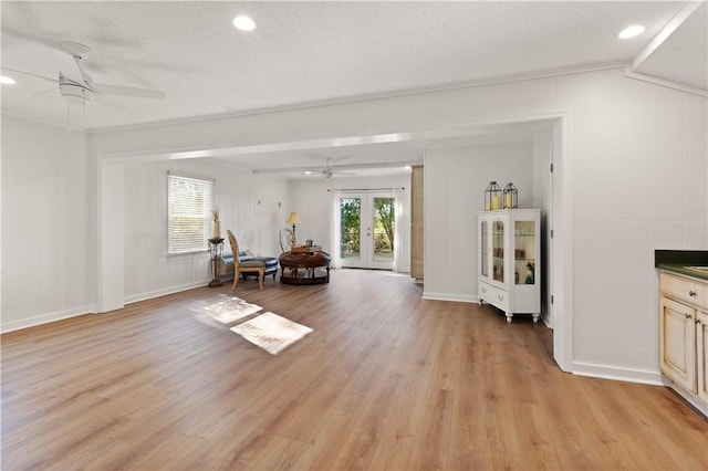 unfurnished room with a textured ceiling, light hardwood / wood-style floors, french doors, and ceiling fan