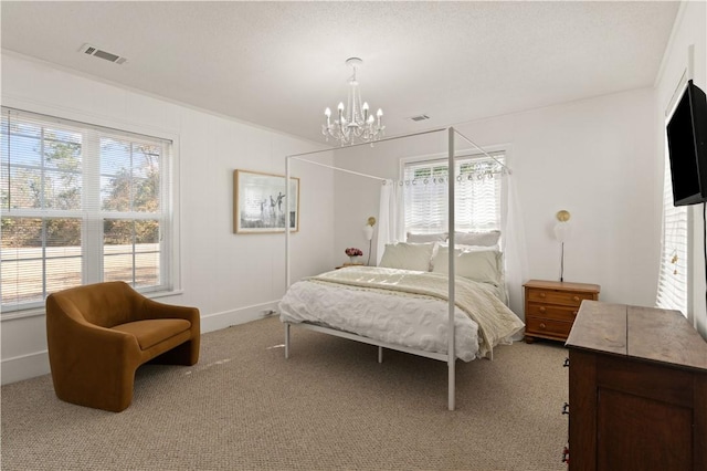 bedroom featuring light carpet and an inviting chandelier