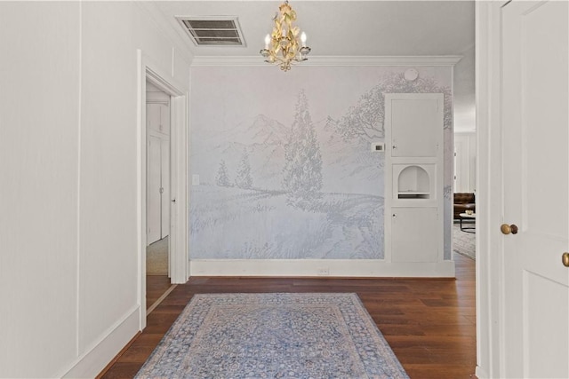 hall with crown molding, dark hardwood / wood-style floors, and a notable chandelier