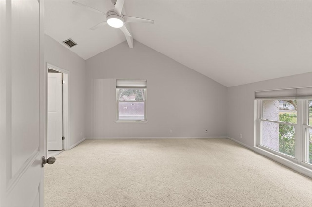 interior space featuring a wealth of natural light, lofted ceiling with beams, light colored carpet, and ceiling fan