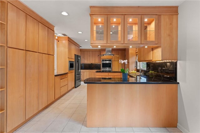 kitchen with kitchen peninsula, refrigerator, tasteful backsplash, island range hood, and stainless steel microwave