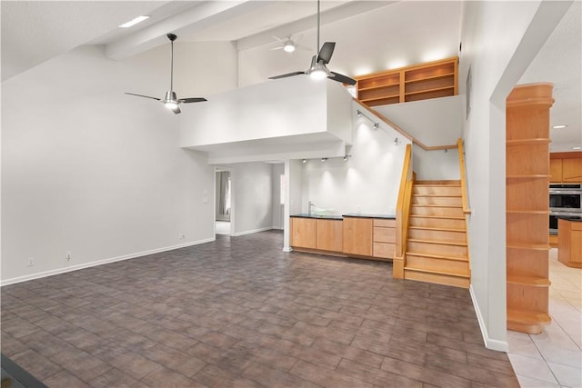 unfurnished living room with ceiling fan, beamed ceiling, and high vaulted ceiling