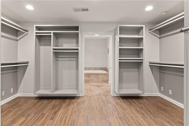 walk in closet with hardwood / wood-style floors