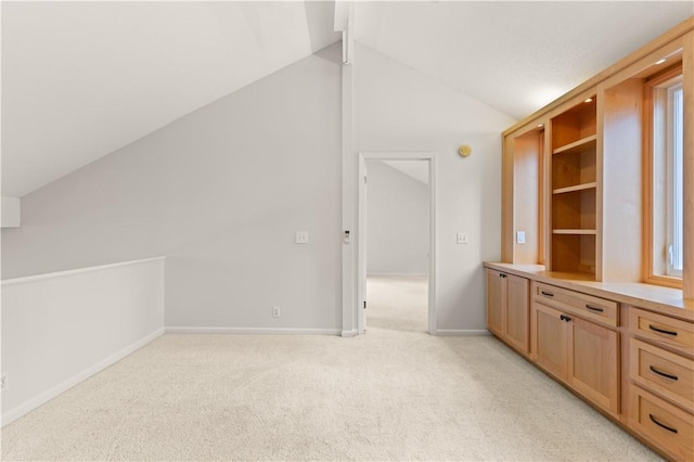 interior space with light colored carpet and vaulted ceiling