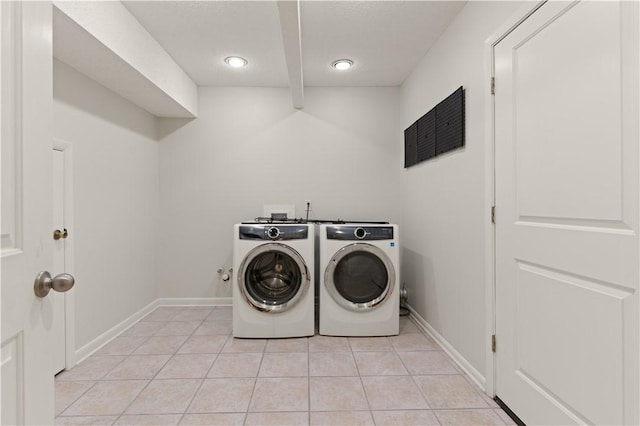 laundry area with washing machine and dryer and light tile patterned floors