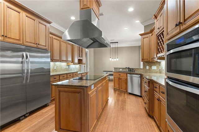 kitchen with a center island, stainless steel appliances, light hardwood / wood-style floors, decorative light fixtures, and island range hood