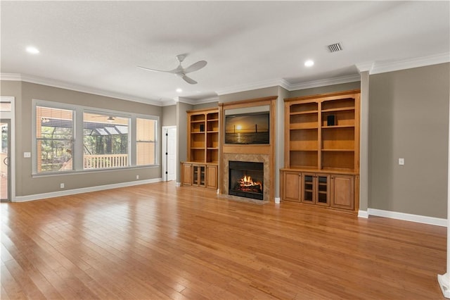 unfurnished living room with ceiling fan, light wood-type flooring, and ornamental molding