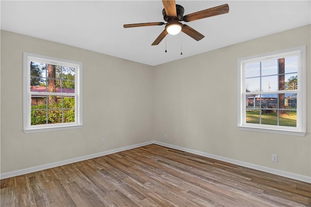 unfurnished room featuring baseboards, a ceiling fan, and wood finished floors