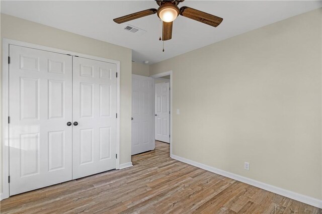 unfurnished bedroom with a closet, baseboards, a ceiling fan, visible vents, and light wood finished floors