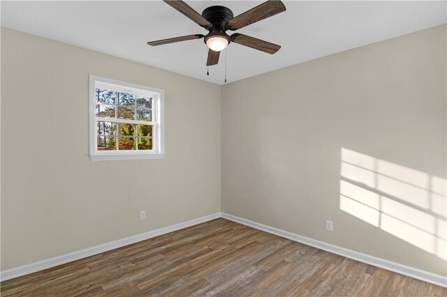empty room with baseboards, a ceiling fan, and wood finished floors