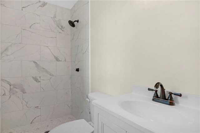 bathroom with a shower stall, vanity, and toilet