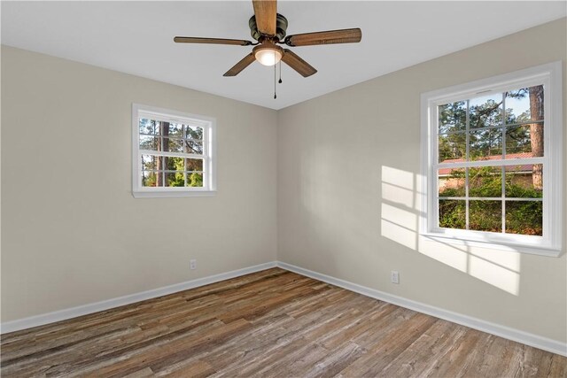 spare room with baseboards, ceiling fan, and wood finished floors