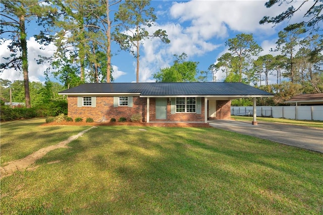 ranch-style house with an attached carport, aphalt driveway, fence, and a front lawn