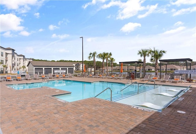 pool with a patio area and fence