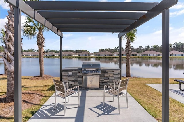 view of patio / terrace with an outdoor kitchen, a water view, and a pergola