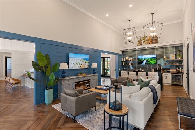 living room with a high ceiling, an inviting chandelier, wine cooler, dark parquet floors, and crown molding