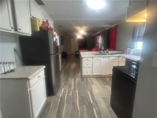 2627 Cleburne St, Brunswick, GA 31520 - kitchen featuring a sink, a peninsula, light wood-style floors, and light countertops
