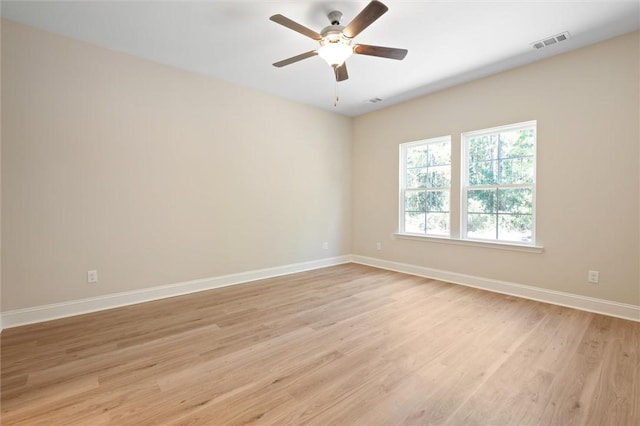 unfurnished room featuring baseboards, ceiling fan, visible vents, and light wood-style floors