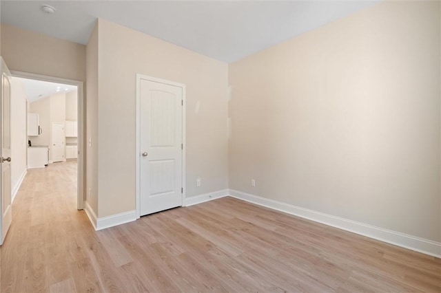 unfurnished room with baseboards and light wood finished floors