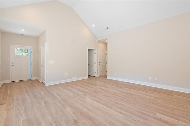 unfurnished living room featuring high vaulted ceiling, light wood-type flooring, baseboards, and recessed lighting