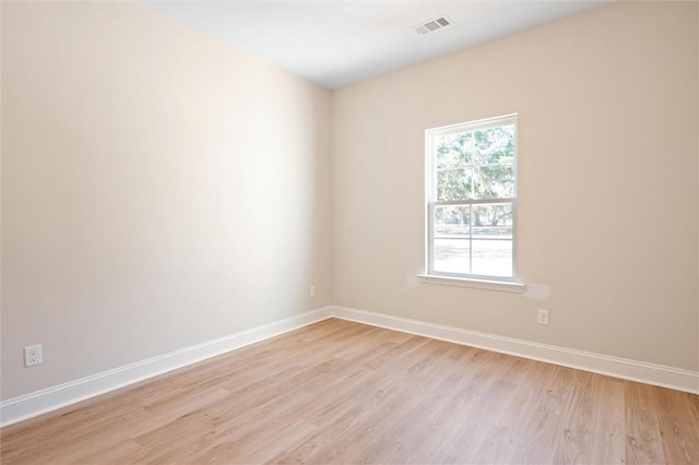 unfurnished room featuring light wood finished floors, baseboards, and visible vents