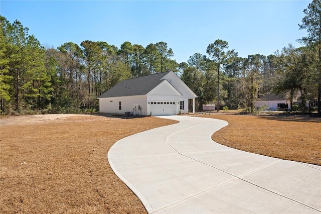 view of front of house with a garage, concrete driveway, and a front lawn