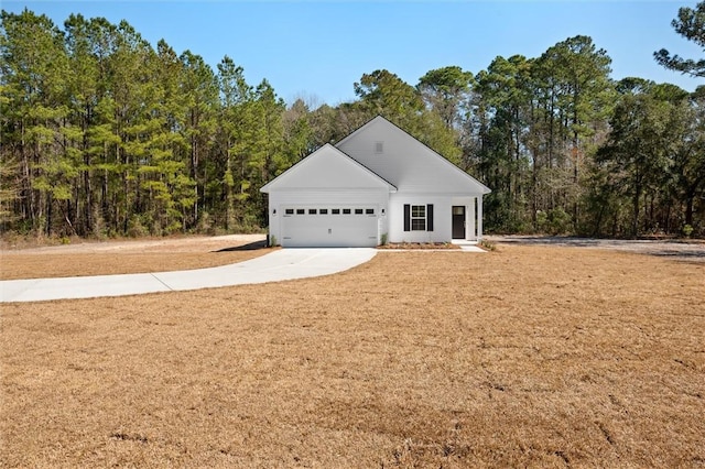 view of front of home featuring a front lawn, concrete driveway, and an attached garage