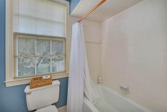 bathroom featuring shower / tub combo and toilet