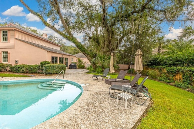 view of pool with a lawn and a patio area