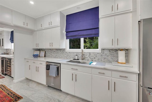 kitchen featuring white cabinets, stainless steel appliances, tasteful backsplash, and sink