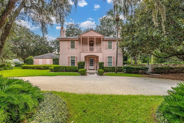 view of front of property featuring a balcony and a front yard