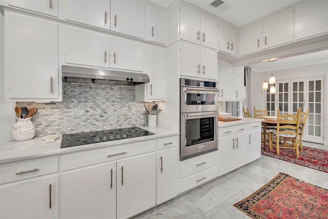 kitchen with double oven, white cabinetry, and black electric stovetop