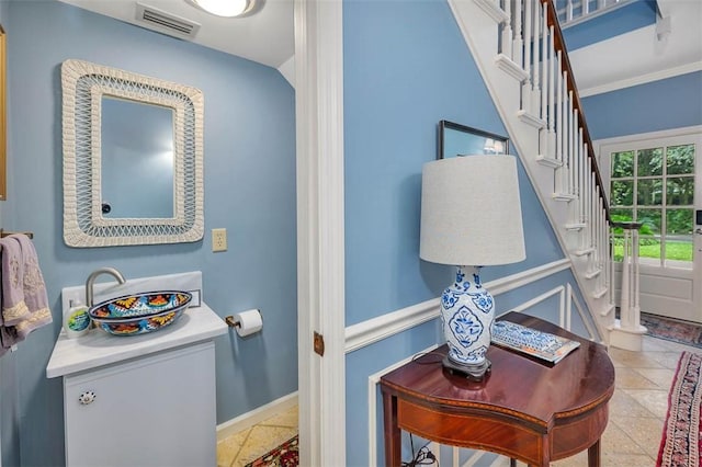 bathroom with ornamental molding and sink