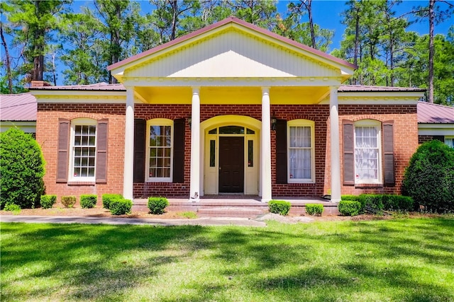 6116 E Main St, Patterson, GA 31557 - greek revival inspired property featuring a porch, a front lawn, brick siding, and metal roof
