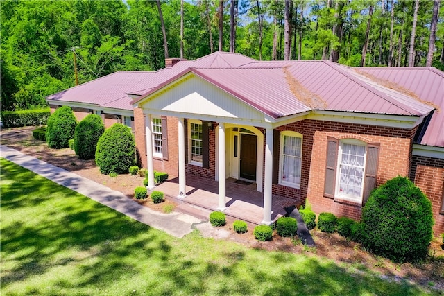 6116 E Main St, Patterson, GA 31557 - view of front of property with covered porch, brick siding, a front yard, and metal roof