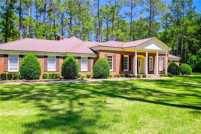 6116 E Main St, Patterson, GA 31557 - view of front of property featuring a chimney, a front lawn, brick siding, and metal roof