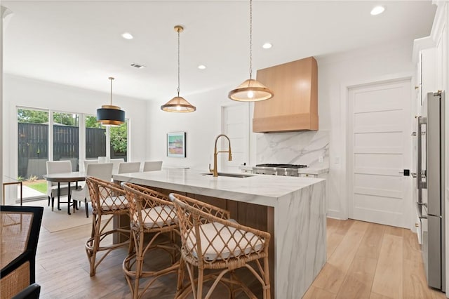 616 Neptune Way, Saint Simons Island, GA 31522 - kitchen with a sink, high end fridge, custom range hood, backsplash, and recessed lighting