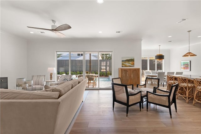 living area with recessed lighting, light wood-style flooring, ceiling fan, and visible vents