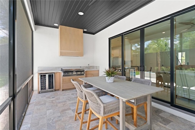 616 Neptune Way, Saint Simons Island, GA 31522 - sunroom with wine cooler, a sink, exterior kitchen, and outdoor dining space