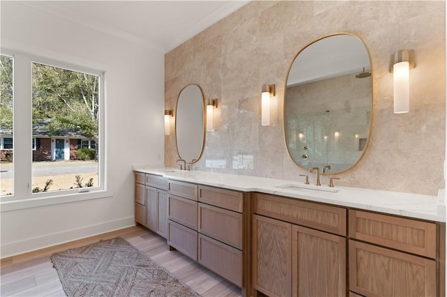 bathroom with double vanity, a sink, a shower, and wood finished floors