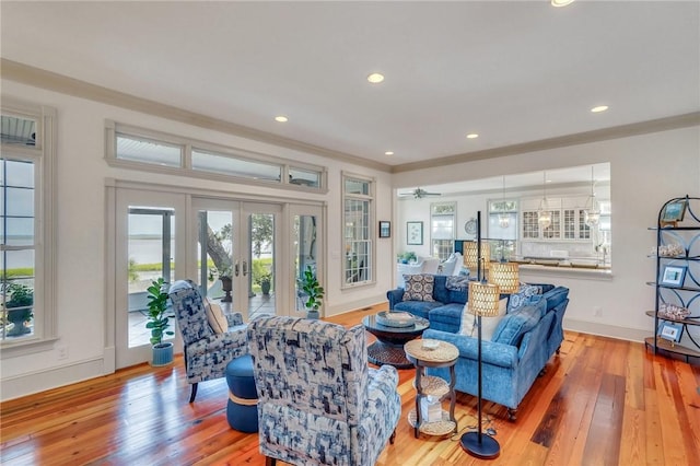 living room with french doors, light hardwood / wood-style floors, ceiling fan, and crown molding