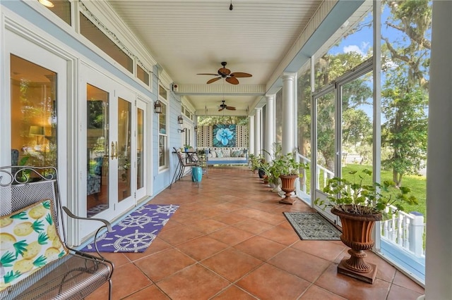 unfurnished sunroom with plenty of natural light, ceiling fan, and decorative columns