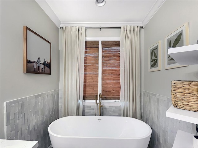 bathroom featuring crown molding, tile walls, and a tub to relax in