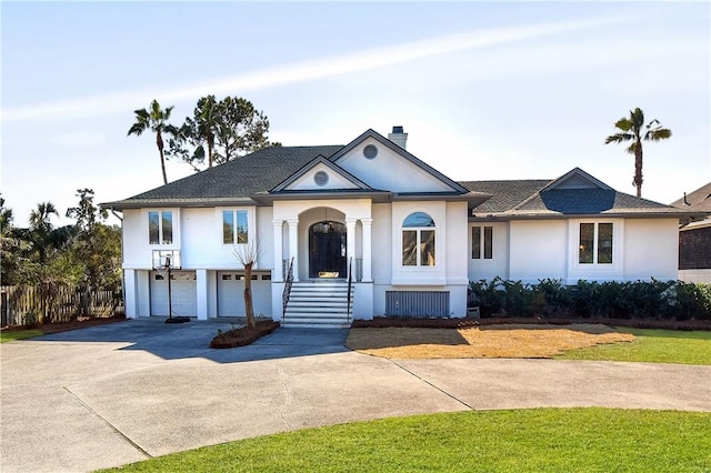 view of front of house featuring concrete driveway, stucco siding, an attached garage, and a chimney