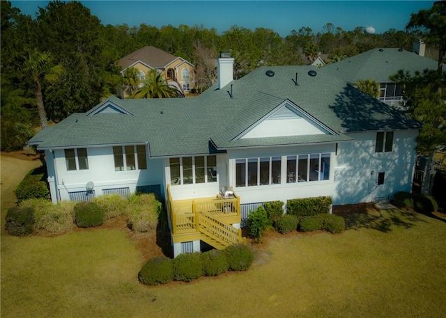 back of house featuring a lawn and a sunroom