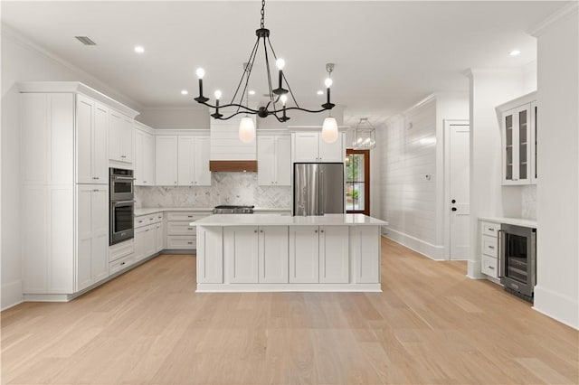 kitchen featuring stainless steel appliances, a chandelier, wine cooler, ornamental molding, and a kitchen island
