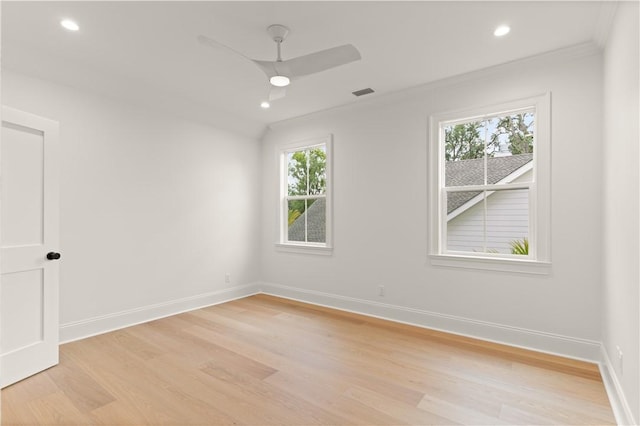 empty room featuring healthy amount of natural light, light wood-type flooring, crown molding, baseboards, and recessed lighting