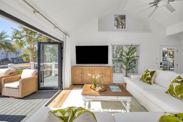 living room with ceiling fan, high vaulted ceiling, and light hardwood / wood-style floors