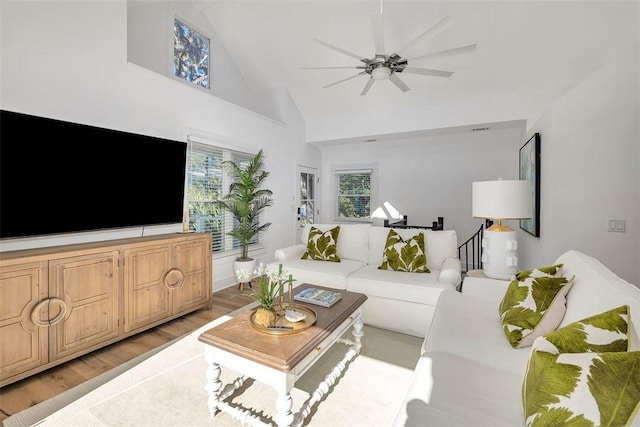 living room with high vaulted ceiling, light hardwood / wood-style flooring, and ceiling fan